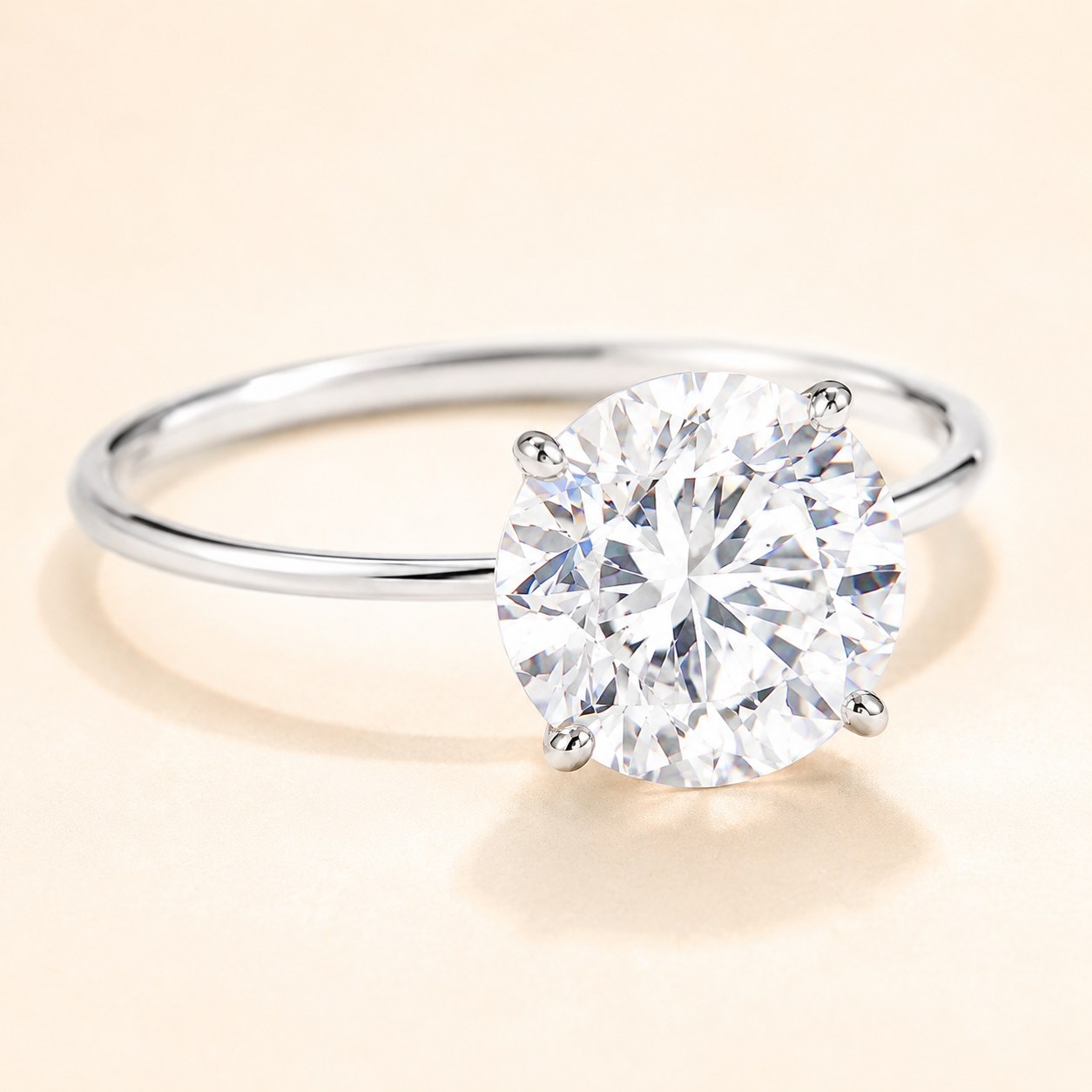 A classic four-prong solitaire engagement ring with a large round diamond on a thin band